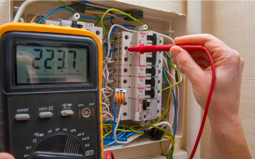 Image of a person using a voltmeter on low voltage wiring