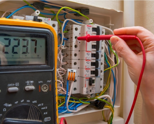 Image of a person using a voltmeter on low voltage wiring