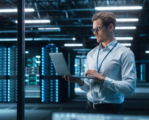 Professional worker looking at code on computer in data center